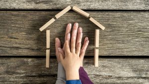 A parent holds their child's hand inside the outline of a wooden house with a title that reads preparing your home for long-term togetherness