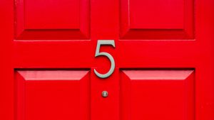 a bright red door with the number 5 on it and a title saying Now is a good time to buy a home
