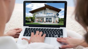 Two people look at a laptop screen showing a house and read Tips for home buyers and sellers
